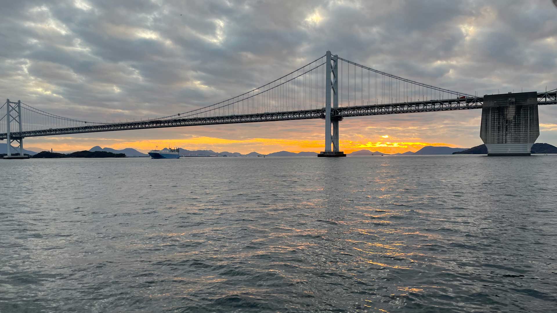 夕焼け空の下に架かる瀬戸大橋と穏やかな海